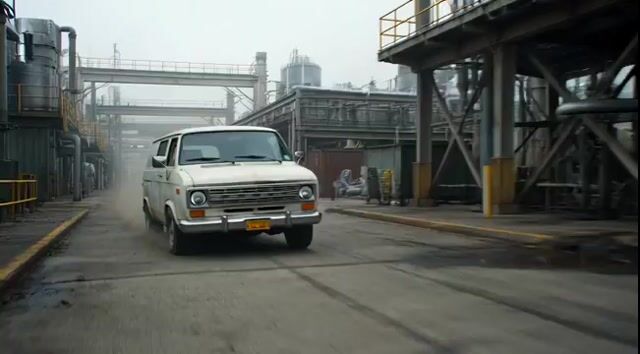 Badass tracking shot of a van speeding through an industrial complex